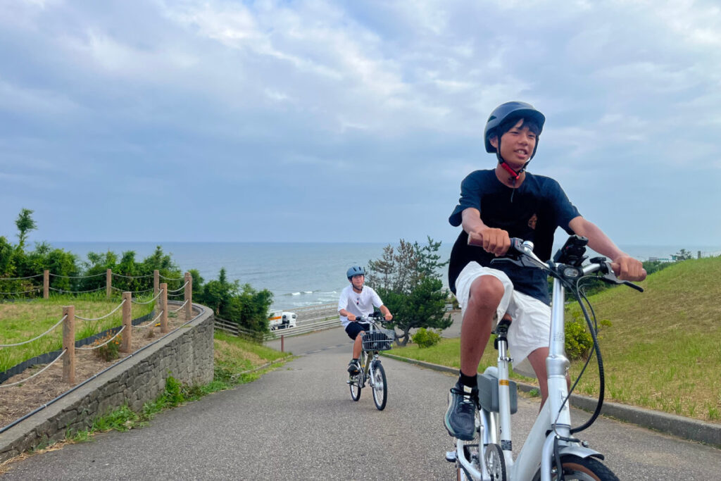 白尾灯台の急な坂道でのe-bike試乗 白尾灯台の急な坂道でのe-bike試乗。その力強いアシスト性能に、誰もが驚きと感動を覚えます。